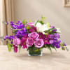 Purple and pink mixed bouquet in a square glass vase
