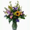 Mixed bouquet in a glass vase with a sunflower and purple blooms