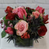 Bouquet of pink and red roses in a square glass vase
