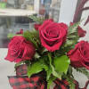 Square box of red roses topped off with a red/black buffalo print