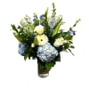Blue and white mixed flower arrangement in a clear glass vase