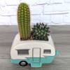 Two small cacti in a camper-shaped ceramic planter