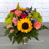 Colorful mixed bouquet with a sunflower in a glass vase
