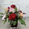 Mixed rose arrangement in a square glass vase
