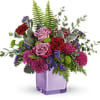 Purple and pink flower arrangement in a lavender vase