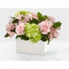 Pink flowers and green hydrangeas arranged in a white box