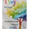 Decorative sign with rainbow tree and the words 'Big things sometimes have small beginnings' on a wood plank background