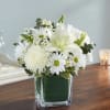 White floral arrangement in a square glass vase