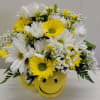 Yellow and white daisy bouquet in a smiley-face mug