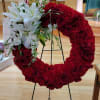 Heart-shaped red floral wreath with white lilies and roses