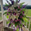 Tall floral standing spray with white lilies and purple blooms