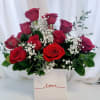 Red roses arranged in a white box with baby's breath