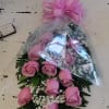Pink rose bouquet wrapped in clear plastic with a pink bow