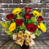 Bouquet of red roses and yellow daisies in a black vase with a sunflower ribbon