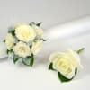 Small ivory rose wedding bouquet with matching single rose boutonniere on a white background