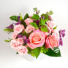 Pink roses and purple flowers arranged in a white vase