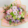 Bouquet of pink, lavender, and white flowers wrapped in pink paper