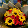 Bouquet of red roses and yellow sunflowers wrapped in dark paper