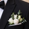 White rose boutonniere in a black suit pocket