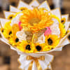 Bouquet of yellow sunflowers and white satin flowers with gold ribbon