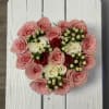 Heart-shaped bouquet of pink and white roses with berry accents