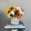 Bouquet of orange and white flowers in a white hat box