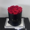Red roses arranged in a black round box