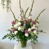 Tall bouquet of purple and white roses in a clear glass vase