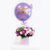 Birthday balloon above a mixed flower arrangement in a pink box