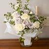 Bouquet of cream and pale lavender roses in white wrap