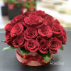 Bouquet of red roses in a round box with a ribbon