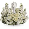 White floral arrangement with roses and a silver angel figurine