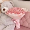Pink rose bouquet held by a large gray teddy bear