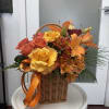 Basket of orange and yellow roses with lilies and ribbon