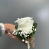 White rose boutonniere with baby's breath and green ribbon