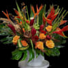 Tropical floral arrangement with orange roses and red heliconia in a white vase
