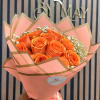 Orange roses wrapped in pink paper with a satin ribbon