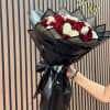 Bouquet of red and white roses wrapped in black paper