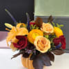 Autumn floral arrangement in a pumpkin container with roses and lilies