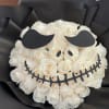White rose bouquet wrapped in black paper with a skull face design