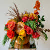 Autumn floral arrangement in a pumpkin container with roses and mums