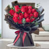 Bouquet of red roses wrapped in black paper with a ribbon
