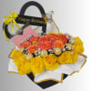 Birthday gift bouquet with yellow and orange roses, chocolates, and a card