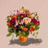 Mixed bouquet of roses, carnations, and alstroemeria in an orange vase