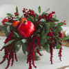 Arrangement with a pomegranate and red berry sprays in a metal vase