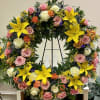 Large floral wreath with pink and white roses and bright yellow lilies