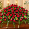 Large red rose casket spray on a wooden coffin