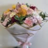 Mixed bouquet of pink, yellow, and white flowers wrapped in white paper