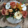 Mixed bouquet in a white pumpkin-shaped vase with roses and daisies