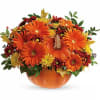 Orange pumpkin-shaped vase with orange and yellow flowers
